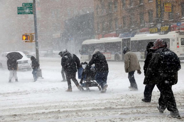 People struggle against wind and snow as they cross 125th street in upper Manhattan during a snowstorm in New York City, New York, U.S., January 4, 2018. REUTERS/Mike Segar