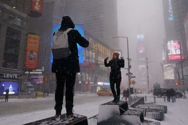 People take photos in Times Square during a snowstorm in New York City, New York, U.S., January 4, 2018. REUTERS/Carlo Allegri