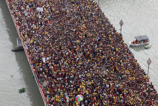 Devotees flock as a carriage bearing an image of Black Nazarene makes its way through the Jones bridge in Manila, Philippines, January 9, 2018. REUTERS/Erik De Castro