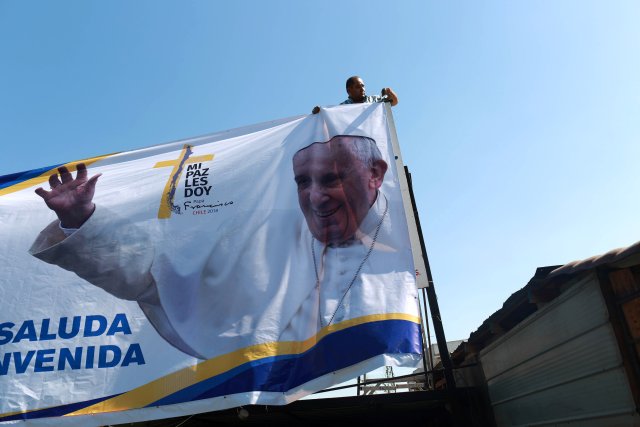 A man arranges a banner with an image of Pope Francis ahead of the papal visit, in Santiago, Chile January 10, 2018. Picture taken January 10, 2018. REUTERS/Pablo Sanhueza