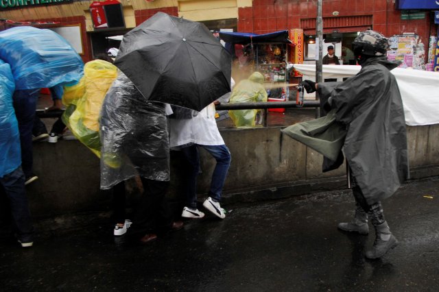 Un policía rocía gas pimienta a manifestantes en La Paz, Bolivia. REUTERS/Christian Lombardi