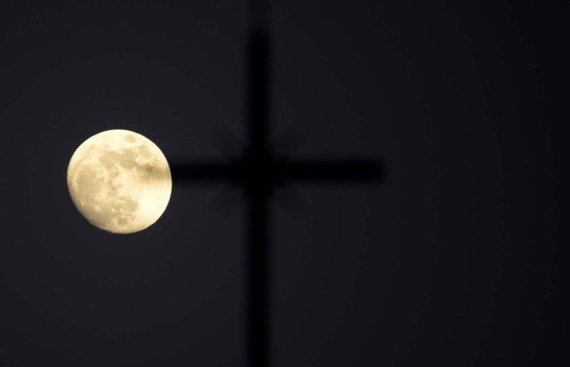 The 'super moon' full moon is seen in front of the cross of a church in Siero, Spain, January 29, 2018. REUTERS/Eloy Alonso