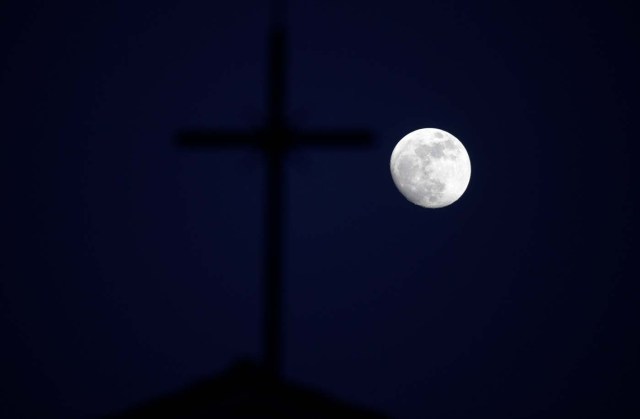 The 'super moon' full moon is seen in front of the cross of a church in Siero, Spain, January 29, 2018. REUTERS/Eloy Alonso