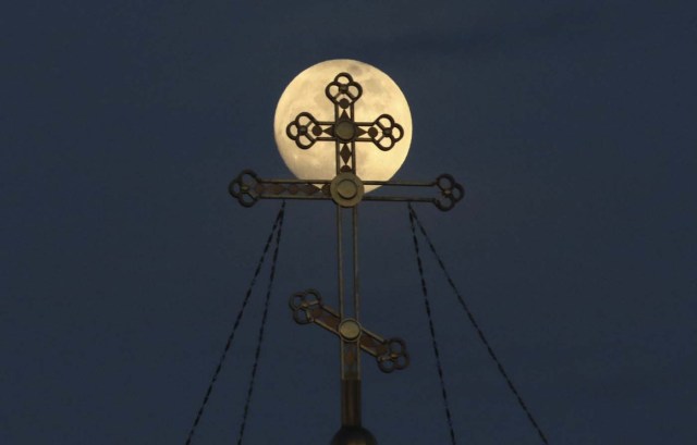 A supermoon rises behind the cross of the Saint Nicholas Cathedral in the Black Sea port of Yevpatoriya, Crimea January 30, 2018. REUTERS/Pavel Rebrov