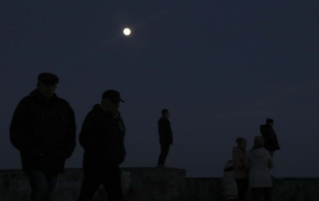 People watch the supermoon in the Black Sea port of Yevpatoriya, Crimea January 30, 2018. REUTERS/Pavel Rebrov