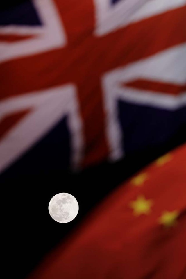 The super blue moon is seen between British and Chinese flags raised at Tiananmen square in Beijing as British Prime Minister Theresa May visit China's capital, January 31, 2018. REUTERS/Damir Sagolj