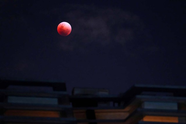 A "Super Blue Blood Moon" rises over an apartment block during a lunar eclipse in Singapore January 31, 2018. REUTERS/Tim Chong