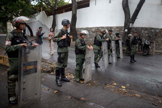 CAR01. CARACAS (VENEZUELA), 17/01/2018.- Miembros de la Guardia Nacional Bolivariana y la Policía Nacional Bolivariana custodian las inmediaciones de la morgue en donde está cuerpo del exagente Pérez hoy, miércoles 17 de enero de 2018, en Caracas (Venezuela). Decenas de agentes de la Policía Nacional Bolivariana custodian desde la mañana de hoy los alrededores de la principal morgue de Caracas, después de que familiares de Óscar Pérez, el exagente alzado contra el Gobierno chavista quien falleció el lunes, exigieran identificar su cuerpo. EFE/MIGUEL GUTIÉRREZ