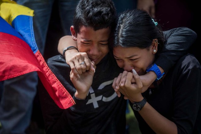 CAR021. CARACAS (VENEZUELA), 20/01/2018. Familiares de José Díaz Pimentel y Abraham Agostini lloran en la parcela donde ambos fueron enterrados hoy, sábado 20 de enero del 2018, en Caracas (Venezuela). Dos de las seis personas abatidas junto al exinspector alzado contra el Gobierno venezolano Óscar Pérez fueron enterrados hoy en medio de denuncias de que los familiares no autorizaron el sepelio, mientras continúa la incertidumbre sobre qué se hará con el cuerpo del líder del grupo. EFE/Miguel Gutiérrez