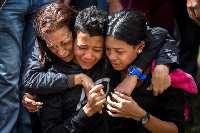 CAR023. CARACAS (VENEZUELA), 20/01/2018. Familiares de José Díaz Pimentel y Abraham Agostini lloran en la parcela donde ambos fueron enterrados hoy, sábado 20 de enero del 2018, en Caracas (Venezuela). Dos de las seis personas abatidas junto al exinspector alzado contra el Gobierno venezolano Óscar Pérez fueron enterrados hoy en medio de denuncias de que los familiares no autorizaron el sepelio, mientras continúa la incertidumbre sobre qué se hará con el cuerpo del líder del grupo. EFE/Miguel Gutiérrez