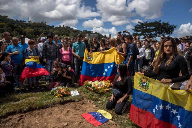 CAR030. CARACAS (VENEZUELA), 20/01/2018. Familiares de José Díaz Pimentel y Abraham Agostini se reúnen en la parcela donde ambos fueron enterrados hoy, sábado 20 de enero del 2018, en Caracas (Venezuela). Dos de las seis personas abatidas junto al exinspector alzado contra el Gobierno venezolano Óscar Pérez fueron enterrados hoy en medio de denuncias de que los familiares no autorizaron el sepelio, mientras continúa la incertidumbre sobre qué se hará con el cuerpo del líder del grupo. EFE/Miguel Gutiérrez