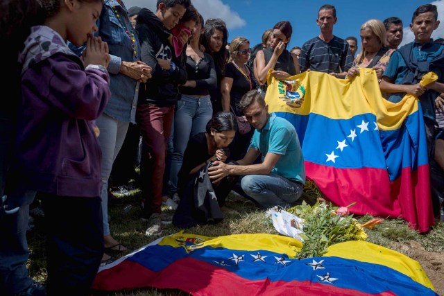 CAR031. CARACAS (VENEZUELA), 20/01/2018. Familiares de José Díaz Pimentel y Abraham Agostini se reúnen en la parcela donde ambos fueron enterrados hoy, sábado 20 de enero del 2018, en Caracas (Venezuela). Dos de las seis personas abatidas junto al exinspector alzado contra el Gobierno venezolano Óscar Pérez fueron enterrados hoy en medio de denuncias de que los familiares no autorizaron el sepelio, mientras continúa la incertidumbre sobre qué se hará con el cuerpo del líder del grupo. EFE/Miguel Gutiérrez