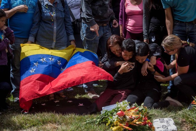 -FOTODELDIA- CAR022. CARACAS (VENEZUELA), 20/01/2018. Familiares de José Díaz Pimentel y Abraham Agostini lloran en la parcela donde ambos fueron enterrados hoy, sábado 20 de enero del 2018, en Caracas (Venezuela). Dos de las seis personas abatidas junto al exinspector alzado contra el Gobierno venezolano Óscar Pérez fueron enterrados hoy en medio de denuncias de que los familiares no autorizaron el sepelio, mientras continúa la incertidumbre sobre qué se hará con el cuerpo del líder del grupo. EFE/Miguel Gutiérrez