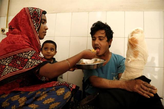  Abul Bajandar (dcha), conocido como 'hombre árbol', recibe comida de manos de su esposa, Halima Akter en una habitación de la unidad de quemados del hospital, en Daca, Bangladés, hoy, 30 de enero de 2018. Bajandar, quien permanecerá dos años en el hospital, ha sido sometido a 19 operaciones para eliminar las verrugas de sus extremidades. EFE/ Abir Abdullah