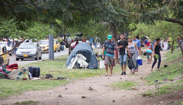 Carpas, cobijas, cajas rotas, telas de toldo les sirven de techo a estos inmigrantes. La grama y la arena hacen de colchones