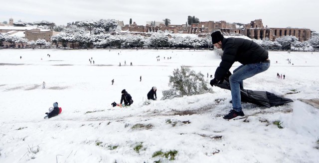 A man prepares to slide with a plastic bag during a heavy snowfall, at the Circus Maximus, in Rome, Italy February 26, 2018. REUTERS/Yara Nardi