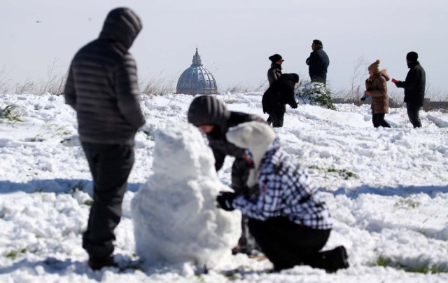 Saint Peter's Basilica is seen in the background as people enjoy the snow following a heavy snowfall at the Circus Maximus in Rome, Italy February 26, 2018. REUTERS/Alessandro Bianchi