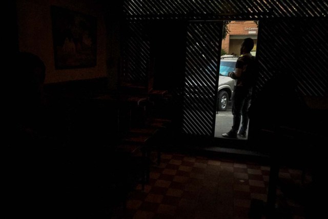 CAR05. CARACAS (VENEZUELA), 06/02/2018.- El encargado de una cafetería cierra el local ante la ausencia de electricidad hoy, martes 06 de febrero de 2018, en Caracas (Venezuela). Varias zonas de Caracas y estados vecinos se quedaron hoy sin electricidad pasadas las 16.00 hora local (20.00 GMT) por razones que aún se desconocen, sin que hasta el momento las autoridades del Gobierno venezolano informen al respecto. EFE/Miguel Gutiérrez