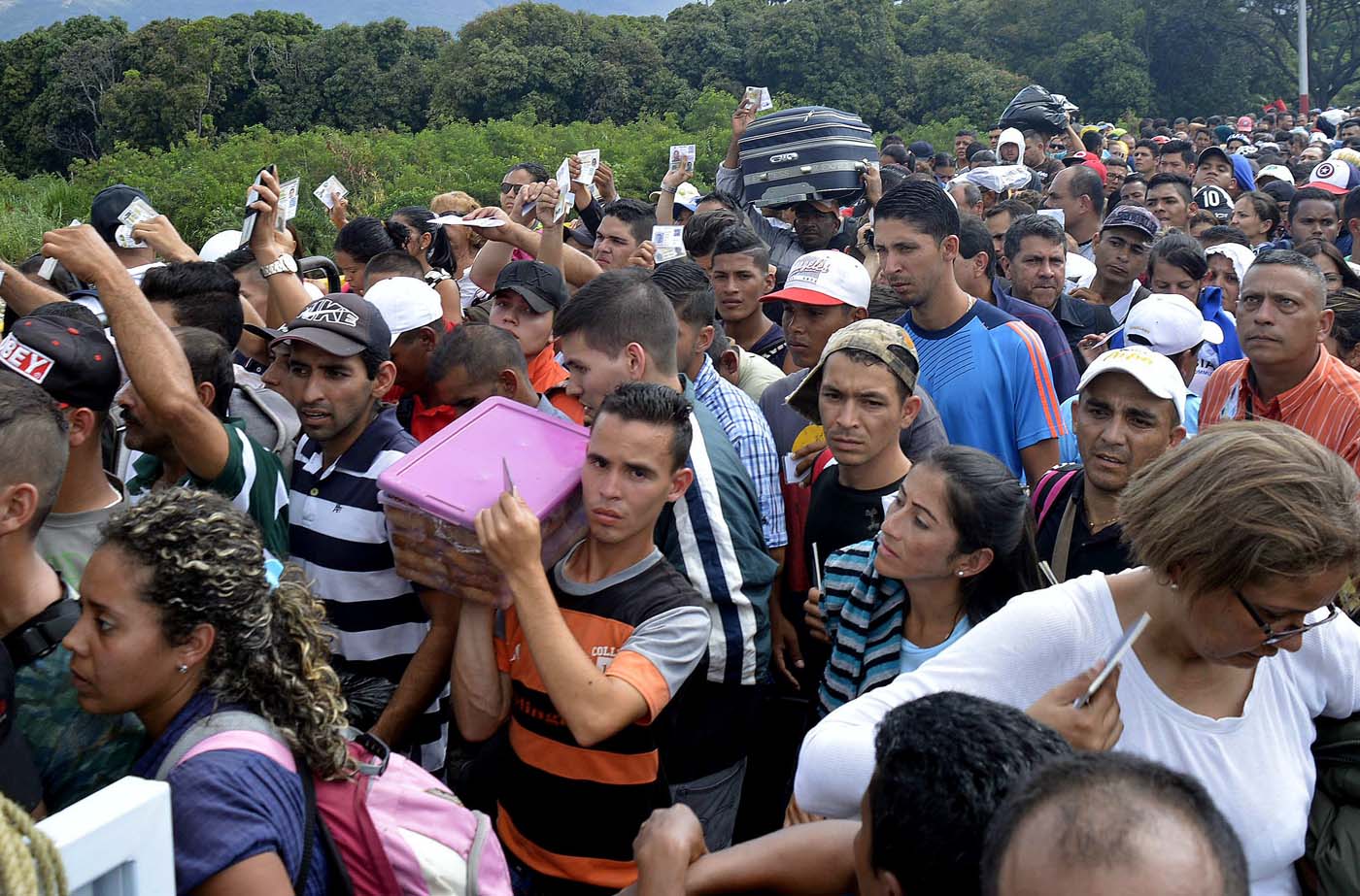 Con bolsos, niños en brazos y casi nada más: La huida desesperada de Venezuela en ruinas