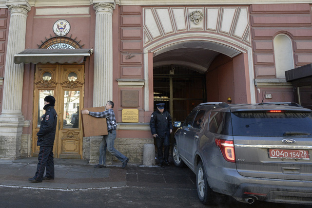 A man moves furniture out of the US Consulate in Saint Petersburg on March 30, 2018. Russia on Thursday announced a mass expulsion of US diplomats and the closure of the US consulate in Saint Petersburg in retaliation to coordinated moves by Western countries to isolate Moscow in the wake of the poisoning of a former double agent in Britain. / AFP PHOTO / OLGA MALTSEVA