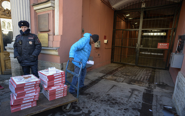 A man delivers pizza at the US Consulate building in Saint Petersburg on March 30, 2018. Russia on Thursday announced a mass expulsion of US diplomats and the closure of the US consulate in Saint Petersburg in retaliation to coordinated moves by Western countries to isolate Moscow in the wake of the poisoning of a former double agent in Britain. / AFP PHOTO / Olga MALTSEVA