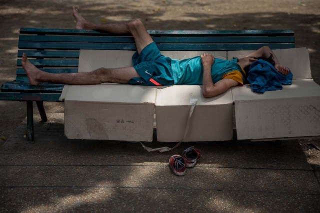 Fotografía del 3 de marzo de 2018 de un adolescente durmiendo en una silla en una plaza en Caracas (Venezuela). La inédita crisis económica y social de Venezuela se hace inocultable en calles y casas de abrigo que a diario reciben a niños que han quedado desamparados después de que sus padres emigraran a otro país a buscar nuevas formas de ingresos y los dejaran a cargo de personas que no pueden mantenerlos. EFE/MIGUEL GUTIÉRREZ