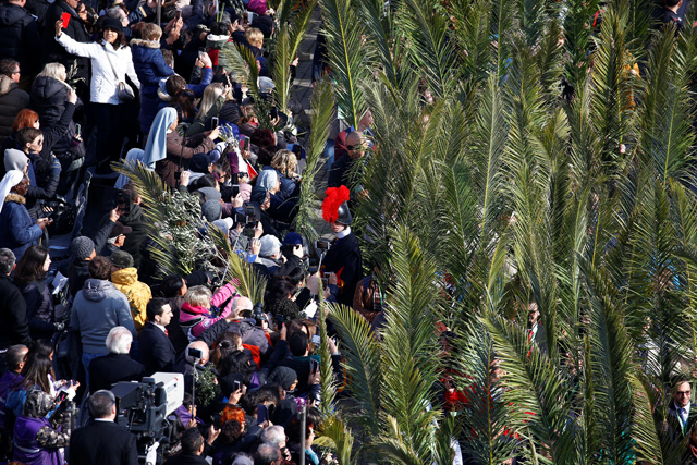 Faithful gather to attend the Palm Sunday Mass in Saint Peter's Square at the Vatican, March 25, 2018 Sign reads "Peace".  REUTERS/Stefano Rellandini