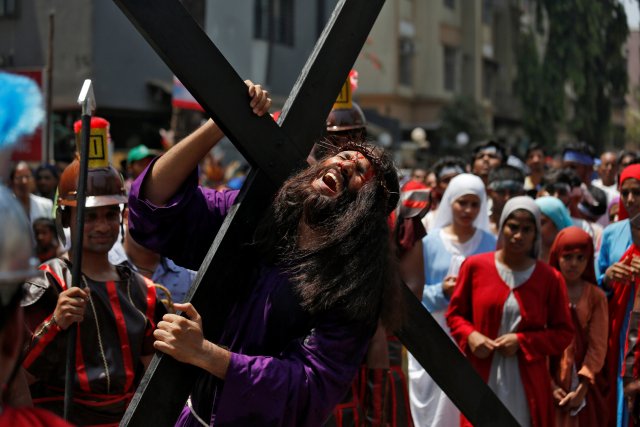 A man portraying Jesus Christ carries a cross while performing a re-enactment during a Good Friday procession in Mumbai, India, March 30, 2018. REUTERS/Francis Mascarenhas