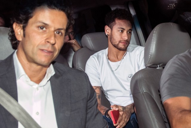 (FILES) In this file photo taken on March 02, 2018 Brazilian superstar Neymar (R), is pictured next to his doctor Rodrigo Lasmar (L), upon his arrival in Belo Horizonte, Minas Gerais state, Brazil, ahead of an operation on his fractured foot.  Neymar and Manuel Neuer, Brazil's best player and the German captain of world champion team, will they be recovered in time for the World Cup 2018 ? That's the question arising for two of the competition's favourites. / AFP PHOTO / NELSON ALMEIDA