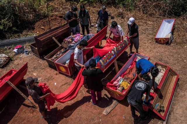 PIC BY Claudio Sieber / CATERS NEWS - (PICTURED For this family, the cleaning ritual MaNene is almost done. The dead are again cosily bedded in their coffins and ready to rest in the familys mausoleum until next time.)THESE images show a unique insight into the village where the living dig up their dead relatives to clean their bones and to dress them up. The dead can even remain in homes for decades until the family throw a huge party in their honour. The corpses are treated as sick until they finally find peace after funeral rites known as Rambu Solo The bizarre ritual was pictured in South Sulawesi, Indonesia, where even buried relatives are taken out of their coffins for new outfits and a bone polish. SEE CATERS COPY