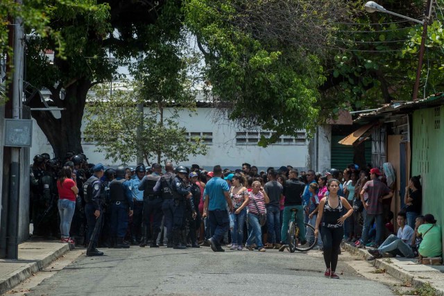 VALENCIA (VENEZUELA), 28/03/2018.- Un grupo de familiares de presos protesta ante miembros de la Policía hoy, miércoles 28 de marzo de 2018, en las inmediaciones del centro de reclusión de la Policía Estatal de Carabobo (centro) en Valencia (Venezuela). Un motín en el centro de reclusión de la Policía de Carabobo (centro) de Venezuela dejó hoy cinco reclusos muertos y dos policías heridos, según medios locales. EFE/Miguel Gutiérrez