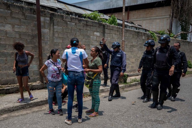 VALENCIA (VENEZUELA), 28/03/2018.- Un grupo de familiares de presos hablan con miembros de la Policía hoy, miércoles 28 de marzo de 2018, en las inmediaciones del centro de reclusión de la Policía Estatal de Carabobo (centro) en Valencia (Venezuela). Un motín en el centro de reclusión de la Policía de Carabobo (centro) de Venezuela dejó hoy cinco reclusos muertos y dos policías heridos, según medios locales. EFE/Miguel Gutiérrez