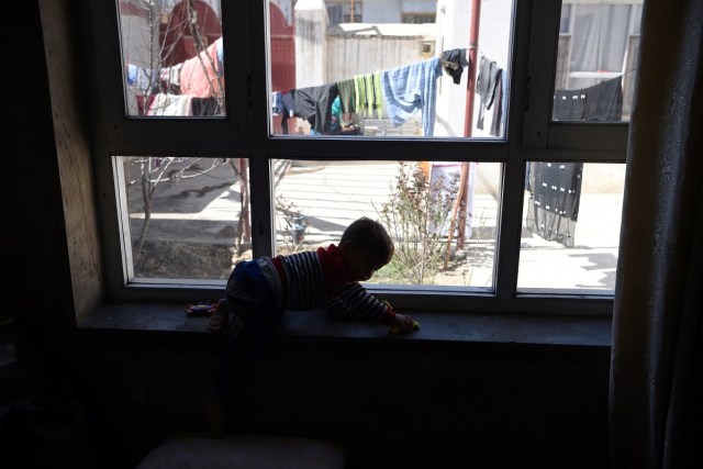 This picture taken on March 16, 2018 shows Afghan toddler Donald Trump, who is aged around 18 months, playing at his home in Kabul. Donald Trump flops over his pink and white baby walker and rolls it around the unfurnished room in Kabul, blissfully unaware of the turmoil his "infidel" name is causing in the conservative Muslim country. The rosy-cheeked toddler, whose parents named him after the more famous Donald Trump in the hope of replicating his success, is at the centre of a social media firestorm after a photo of his Afghan ID papers was posted on Facebook. / AFP PHOTO / Wakil KOHSAR / TO GO WITH 'AFGHANISTAN-PEOPLE-RELIGION' BY ALLISON JACKSON AND MUSHTAQ MOJADDIDI