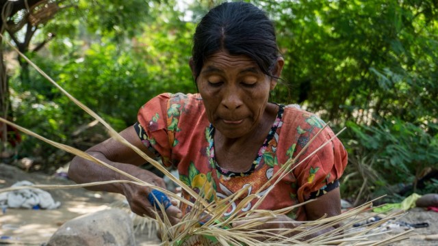 Una anciana Yukpa está tejiendo una canasta que se vende para ayudar a la comunidad (Bram Ebus / Al Jazeera)