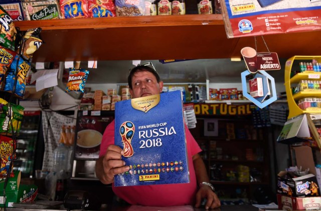 A newsstand vendor shows the collectible trading card album Russia 2018 in Caracas on April 2, 2018. Due to the economic crisis in Venezuela, fans are not able to collect the FIFA World Cup Russia 2018 picture cards. / AFP PHOTO / FEDERICO PARRA / TO GO WITH AFP STORY BY ALEXANDER MARTINEZ