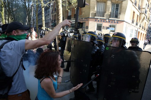 Los manifestantes se enfrentan a la policía antidisturbios de CRS durante una manifestación el 19 de abril de 2018 en París, como parte de un día de protesta de varias ramas convocado por los sindicatos franceses CGT y Solidaires contra las políticas del presidente francés en medio de una huelga ferroviaria y la difusión de sentadas estudiantiles . El presidente de Francia se enfrentó a protestas masivas el 19 de abril cuando los sindicalistas buscan galvanizar a los estudiantes enojados, los trabajadores del sector público y los conductores de trenes en huelga en un movimiento conjunto en contra de su impulso múltiple para reformar la economía francesa. / AFP PHOTO / Zakaria ABDELKAFI