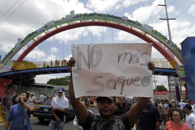 Un residente del barrio "Rubenia" sostiene un letrero que dice "No más saqueos" dentro de las protestas contra las reformas del gobierno en el Instituto de Seguridad Social (INSS), en Managua el 22 de abril de 2018. Violentas protestas contra un cambio propuesto a la pensión de Nicaragua El sistema dejó al menos 20 muertos, según un organismo local de derechos humanos. El Centro Nicaragüense de Derechos Humanos dijo que aún estaba tratando de verificar las cifras, pero que al menos 20 personas habían muerto desde que estallaron las protestas en el país centroamericano el 18 de abril por la reforma de las pensiones.  INTI OCON / AFP