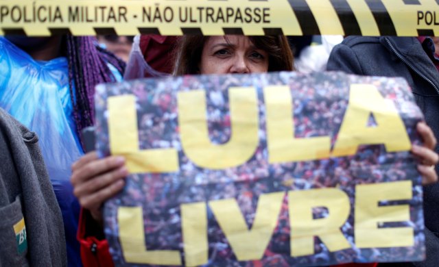 Un partidario del ex presidente brasileño Luiz Inácio Lula da Silva protesta frente a la sede de la Policía Federal, donde Lula está encarcelado, en Curitiba, Brasil, el 17 de abril de 2018. El letrero dice: "Lula gratis". REUTERS / Rodolfo Buhrer