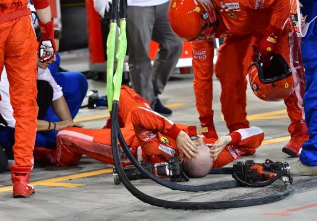 A pitman receives medical assistant following an accident during the pit stop of Ferrari's Finnish driver Kimi Raikkonen during the Bahrain Formula One Grand Prix at the Sakhir circuit in Manama on April 8, 2018.  / AFP PHOTO / POOL AND AFP PHOTO / Giuseppe CACACE