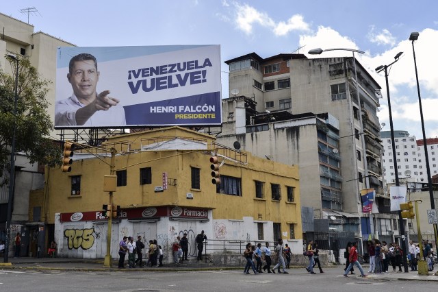 Vista de una cartelera con publicidad electoral del candidato presidencial opositor venezolano Henri Falcon en Caracas el 11 de mayo de 2018. Los ciudadanos venezolanos enfrentarán elecciones presidenciales el 20 de mayo en medio de una severa crisis socioeconómica, con hiperinflación, estimada en 13.800% por el FMI para 2018 - y la escasez de alimentos, medicinas y otros productos básicos. / AFP PHOTO / Luis ROBAYO