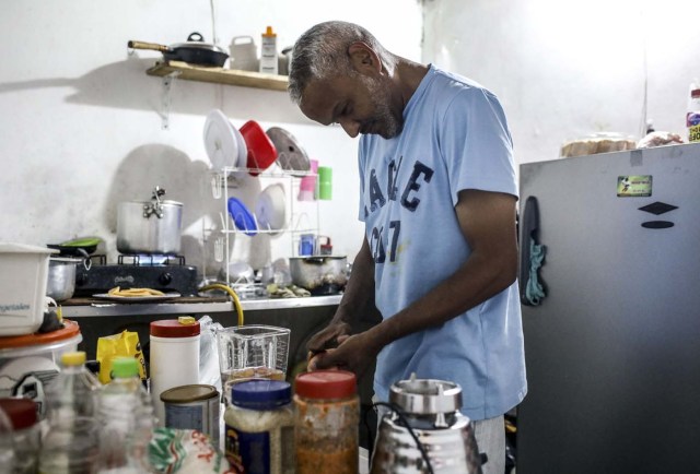 Venezuelan Carlos Figueroa cooks at his home in Medellin, Colombia, on May 10, 2018. Exiled Venezuelans have no expectations of the presidential election taking place next May 20 in their home country. / AFP PHOTO / JOAQUIN SARMIENTO