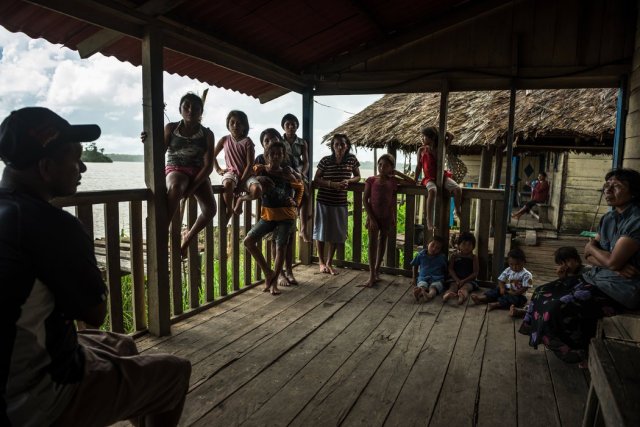 Rafael Pequeño, a la izquierda, hablaba con Tiburcia Sakobara, a la derecha, maestra de la escuela de Jeukubaka, una aldea del delta del Orinoco. Credit Meridith Kohut para The New York Times