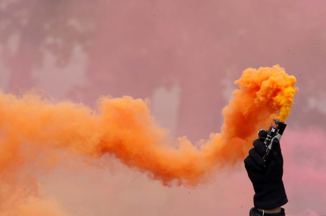Un manifestante sostiene una llamarada de seguridad contra el humo durante la marcha sindical del Primero de Mayo en París, Francia, el 1 de mayo de 2018. REUTERS / Christian Hartmann