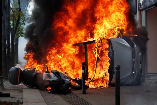 Un automóvil se quema frente a un garaje de automóviles de Renault durante los enfrentamientos en la marcha sindical del Primero de Mayo en París, Francia, el 1 de mayo de 2018. REUTERS / Christian Hartmann