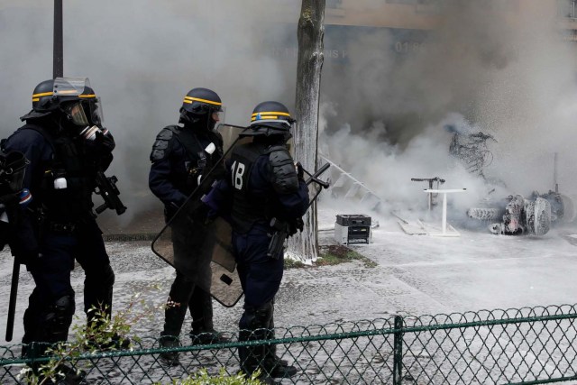 La policía antidisturbios francesa de CRS toma posición cerca de los restos de un vehículo fuera de un garaje de Renault durante los enfrentamientos en la marcha sindical del Primero de Mayo en París, Francia, el 1 de mayo de 2018. REUTERS / Philippe Wojazer