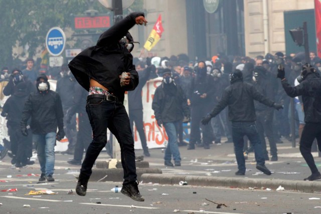 Un manifestante enmascarado arroja una piedra durante los enfrentamientos en la marcha sindical del Primero de Mayo en París, Francia, el 1 de mayo de 2018. REUTERS / Philippe Wojazer