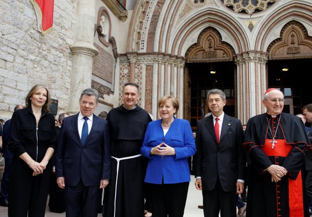 La canciller Angela Merkel posa con el presidente colombiano Juan Manuel Santos (2 ° L), el cardenal Agostino Vallini (R) y el monje católico Mauro Gambetti (3 ° L) en la Basílica de San Francisco en Asís, Italia, el 12 de mayo de 2018. REUTERS / Yara Nardi