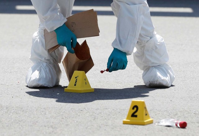 A police forensic investigator collects evidence at Bombay Bhel restaurant, where two unidentified men set off a bomb late Thursday night, wounding fifteen people, in Mississauga, Ontario, Canada May 25, 2018. REUTERS/Mark Blinch