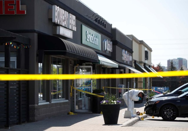 A police forensic investigator photographs evidence at Bombay Bhel restaurant, where two unidentified men set off a bomb late Thursday night, wounding fifteen people, in Mississauga, Ontario, Canada May 25, 2018. REUTERS/Mark Blinch