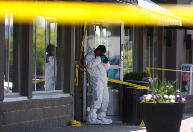 A police forensic investigator photographs evidence at Bombay Bhel restaurant, where two unidentified men set off a bomb late Thursday night, wounding fifteen people, in Mississauga, Ontario, Canada May 25, 2018. REUTERS/Mark Blinch